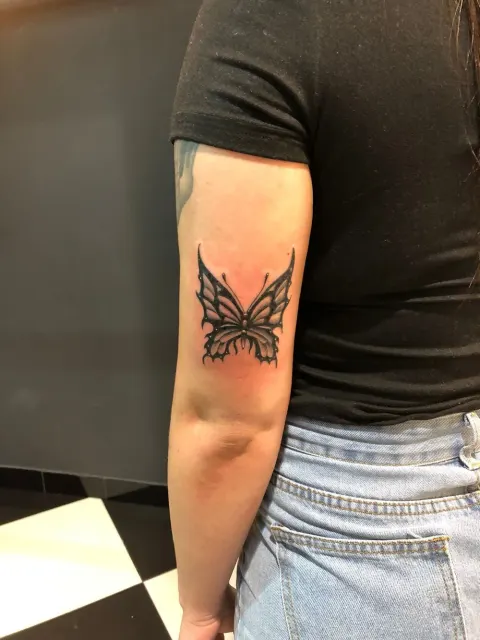 Bold butterfly tattoo on the back of the arm, by Chad Solomon