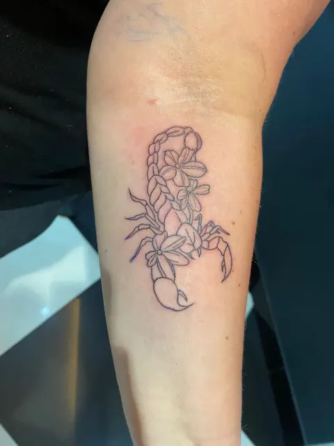 Floral scorpion outline tattoo on the forearm, by Chad Solomon