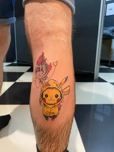 Pikachu in a raincoat tattoo on the calf, by Chad Solomon