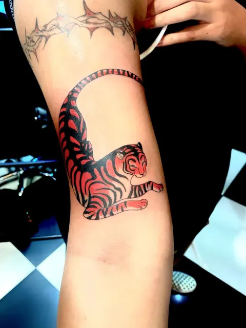 Red tiger tattoo on the inner arm, by Chad Solomon