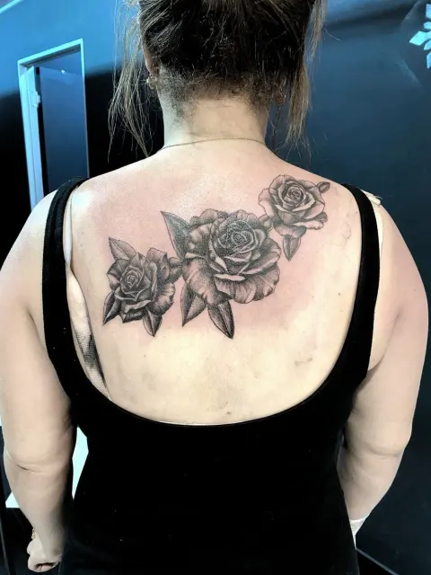 Black and grey roses across the upper back, by Chad Solomon