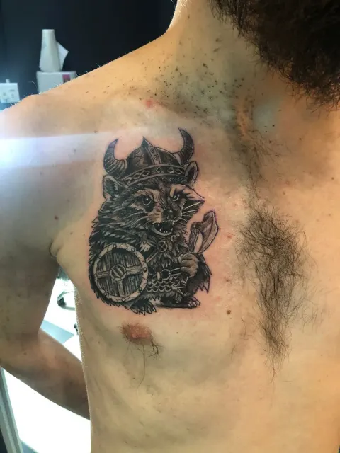 Raccoon in a Viking helmet with a shield and axe, chest tattoo, by Chad Solomon