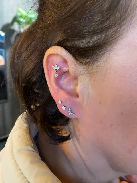 Curated ear with a helix cluster and three lobe piercings, by Chandre Louw