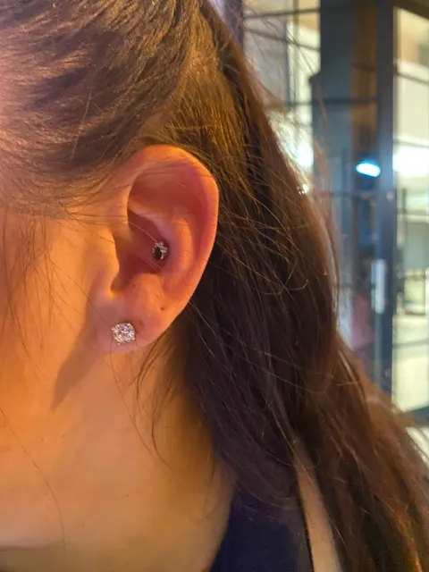 Daith piercing with a lobe stud, by Chandre Louw