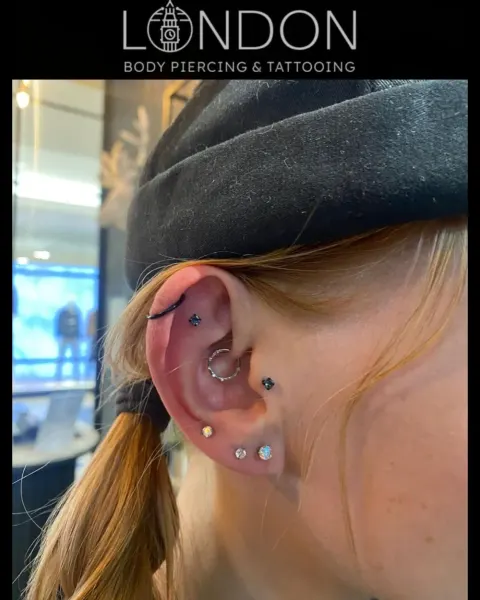 Daith hoop with rook and lobe piercings, by Chandre Louw