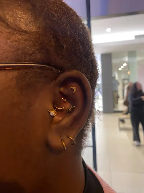 Gold daith, conch and lobe piercings, by Chandre Louw