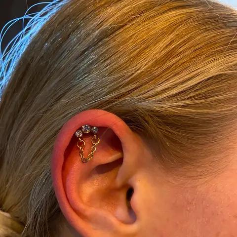 Helix piercings joined with a chain, by Chandre Louw