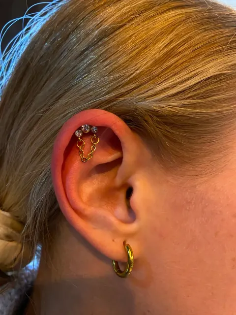 Helix piercings joined with a chain, by Chandre Louw