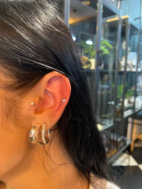 Helix piercing with stacked lobe hoops, by Chandre Louw