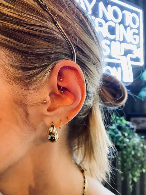 Rook piercing with a lobe drop, by Chandre Louw