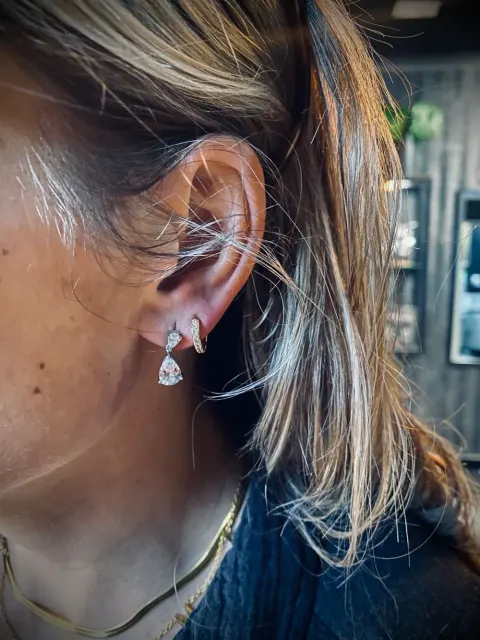 Stacked lobe piercings with drops, by Chandre Louw