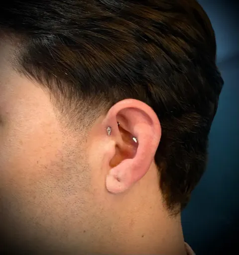 Tragus and helix piercings, by Chandre Louw