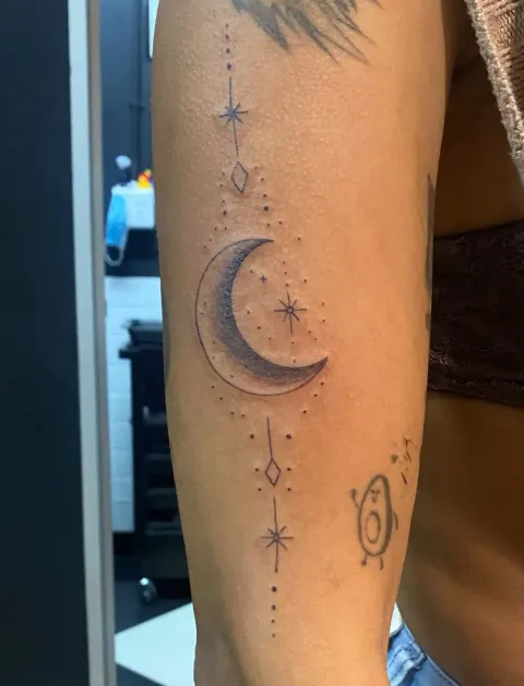 Crescent moon and stars ornamental tattoo on the forearm, by Kayla Grimwood