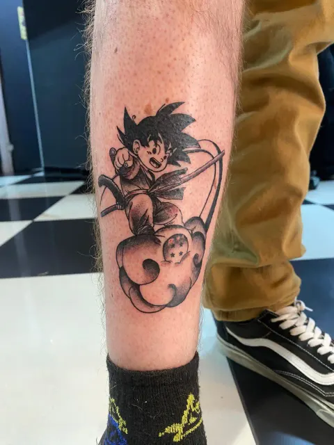 Goku on the Flying Nimbus tattoo on the calf, by Kayla Grimwood