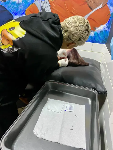 Kelsey Messiah piercing an ear beside a tray of sterile, ready jewellery