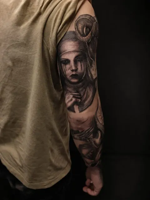 Black and grey portrait sleeve with a crying woman on the upper arm, by Rob Turner