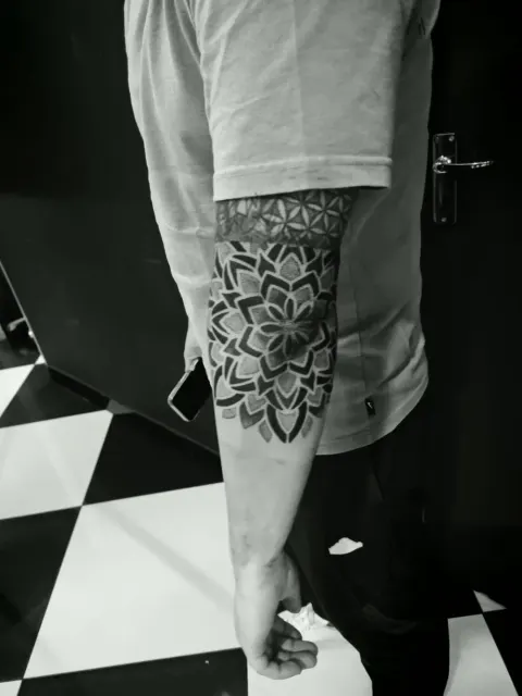 Mandala and sacred geometry dotwork sleeve around the elbow, by Rob Turner