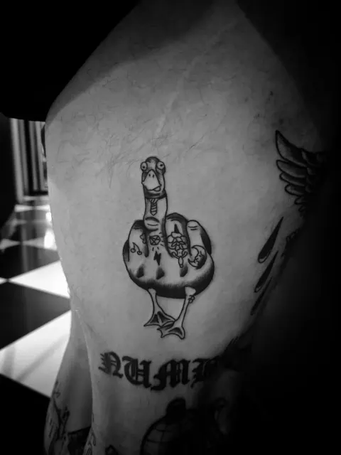 Cartoon duck giving the middle finger tattoo, by Rob Turner