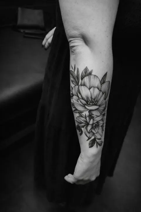 Black and grey peony flowers on the forearm, by Rob Turner
