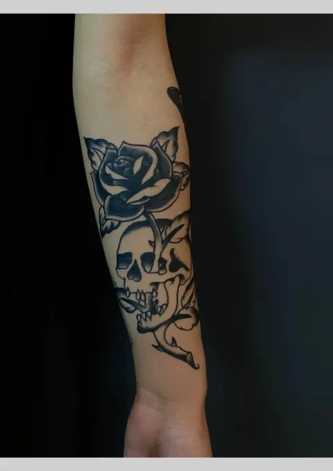 Rose and skull tattoo on the forearm, by Rob Turner