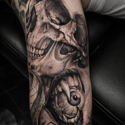 Skull and eye sleeve detail tattoo on the forearm, by Rob Turner