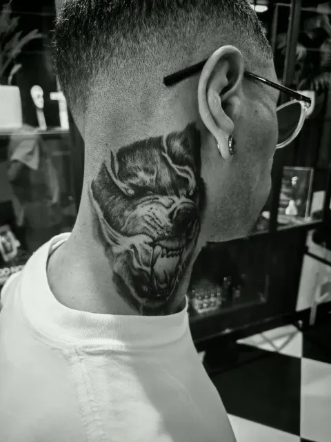 Snarling wolf tattoo on the side of the neck, by Rob Turner