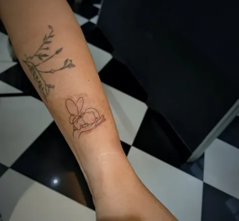 Bee on a branch tattoo on the forearm, by Tayla Symons