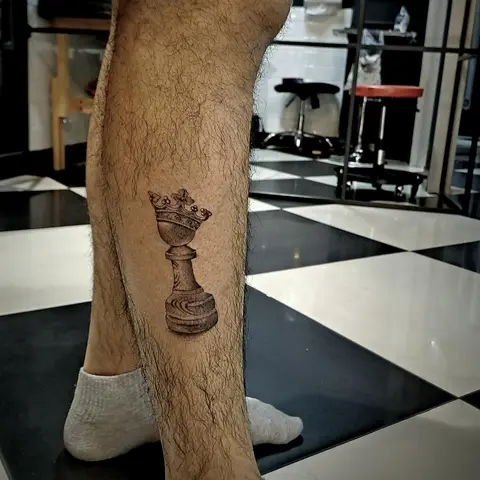 Chess king piece tattoo on the calf, by Tayla Symons