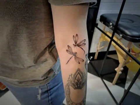 Dragonfly tattoo on the forearm, by Tayla Symons