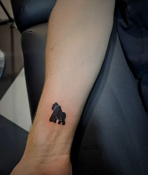 Minimal gorilla silhouette tattoo on the wrist, by Tayla Symons