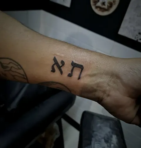 Hebrew letters tattoo on the wrist, by Tayla Symons