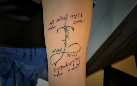 Infinity sign and anchor with script and dates on the forearm, by Tayla Symons