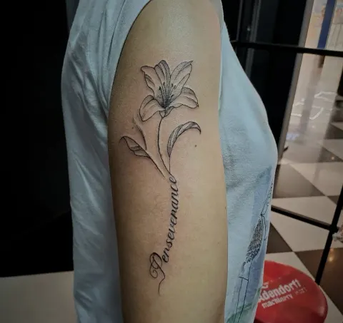 Lily with Perseverance script on the upper arm, by Tayla Symons
