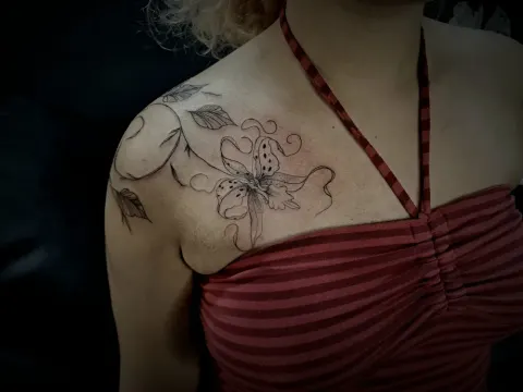 Lily and vine across the shoulder and collarbone, by Tayla Symons