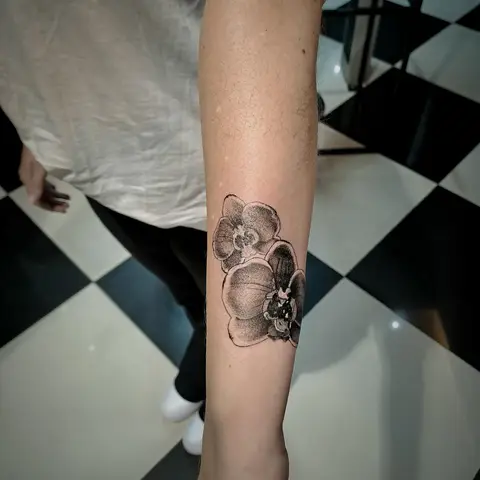 Orchid tattoo on the forearm, by Tayla Symons