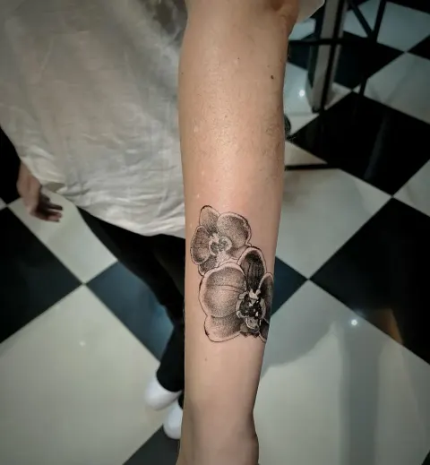 Orchid tattoo on the forearm, by Tayla Symons