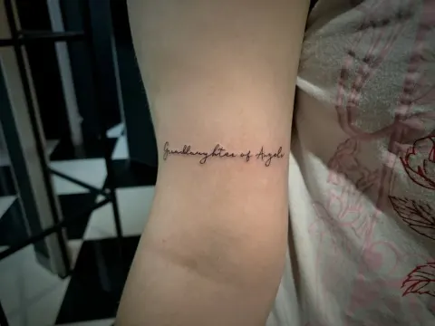 Script lettering around the upper arm, by Tayla Symons