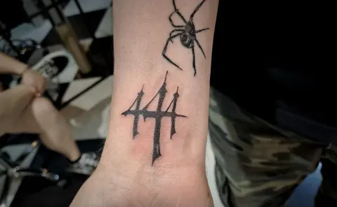Spider and trident tattoo on the wrist, by Tayla Symons